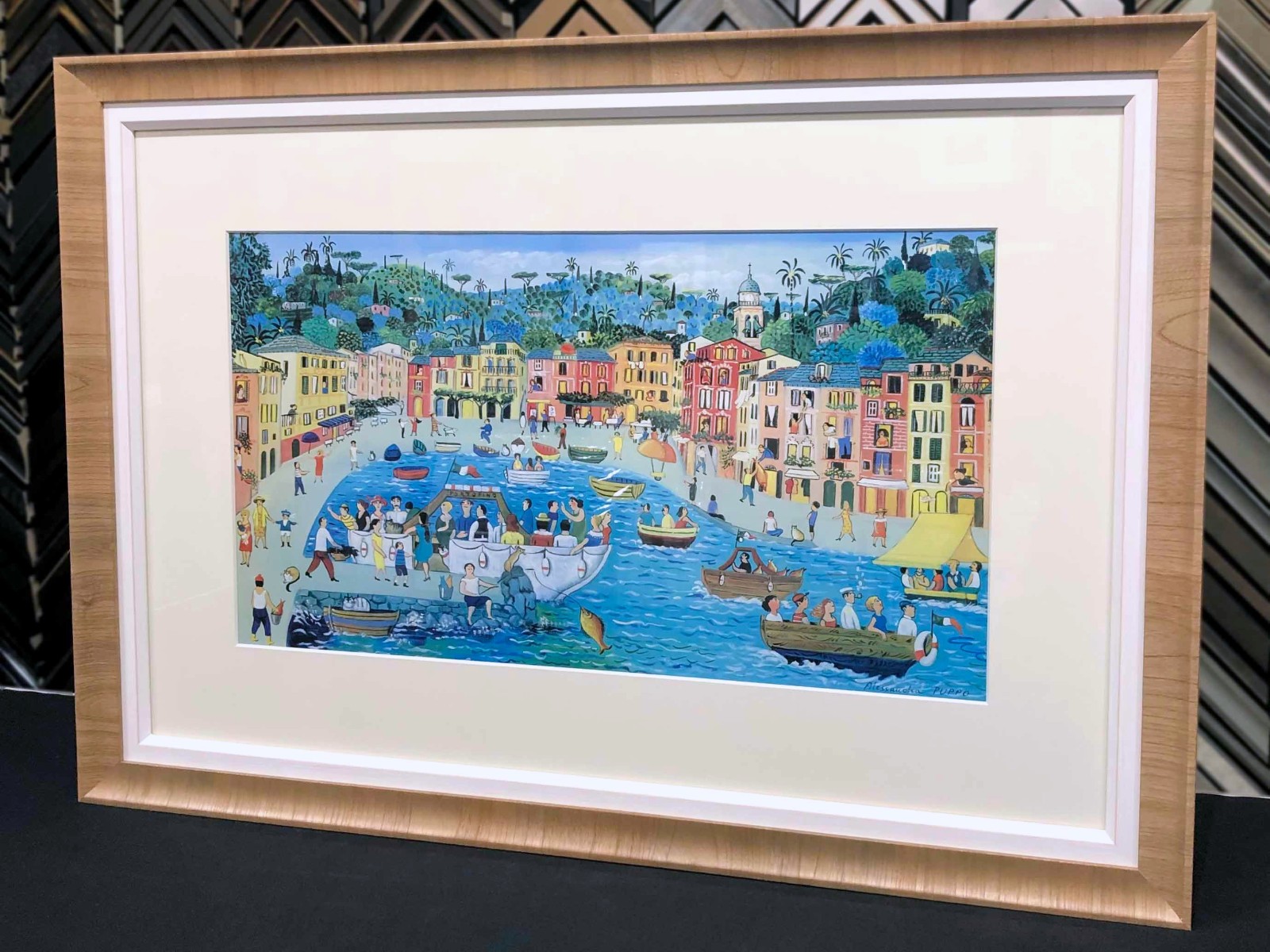 A Portofino harbor painting in an ornate gold frame.