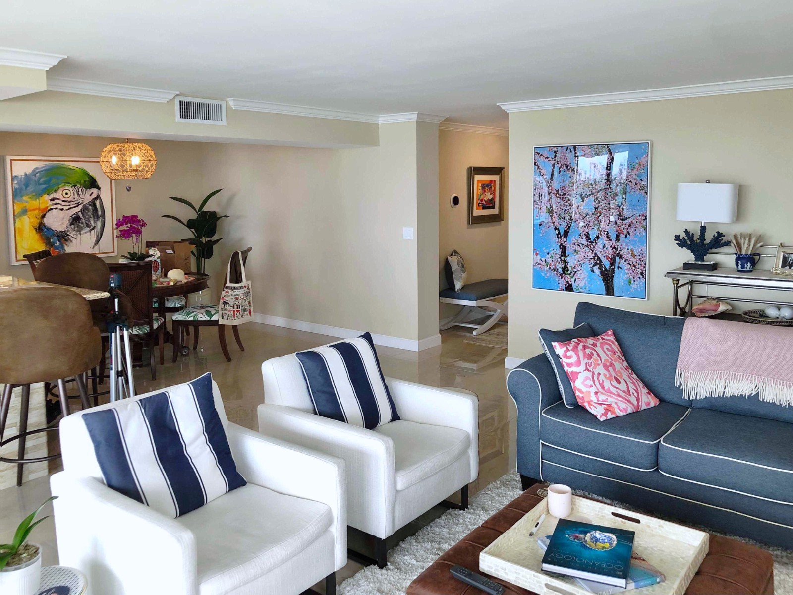 Beachside living room with framed art near bright windows.