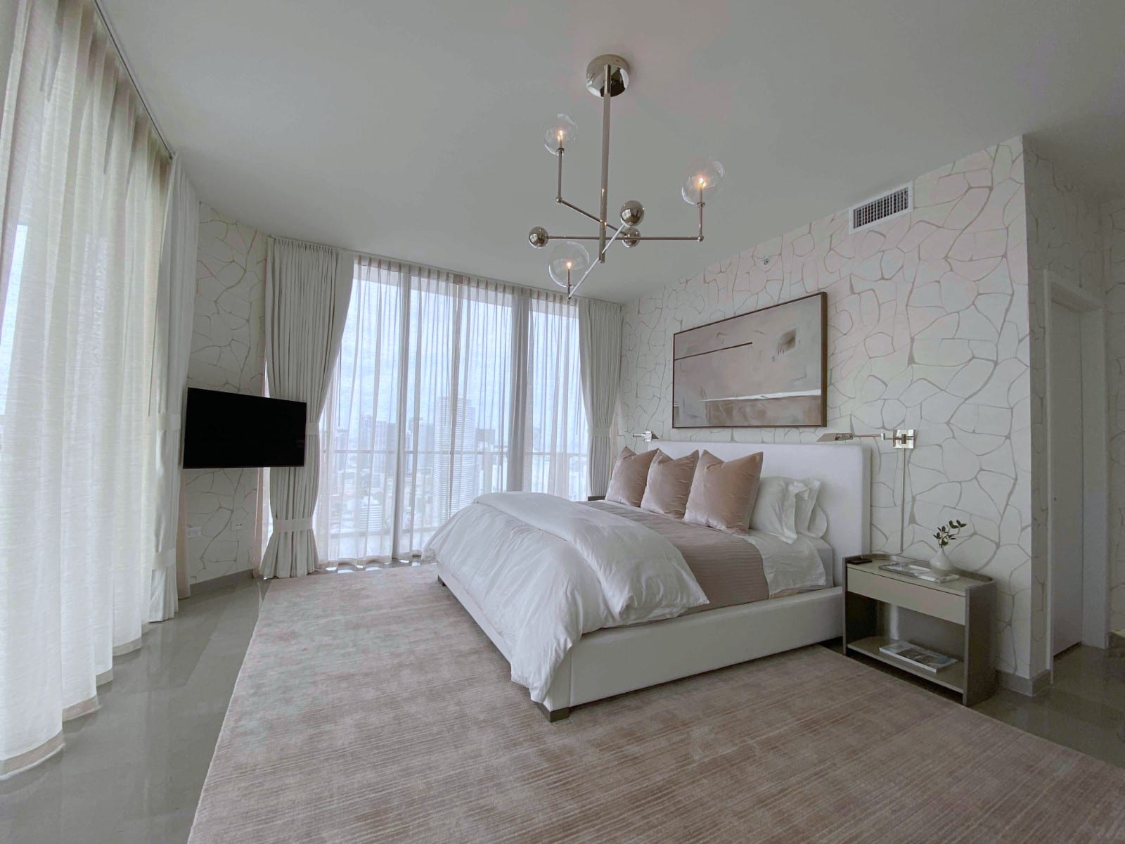 A muted canvas in a wood floater frame over a bed.