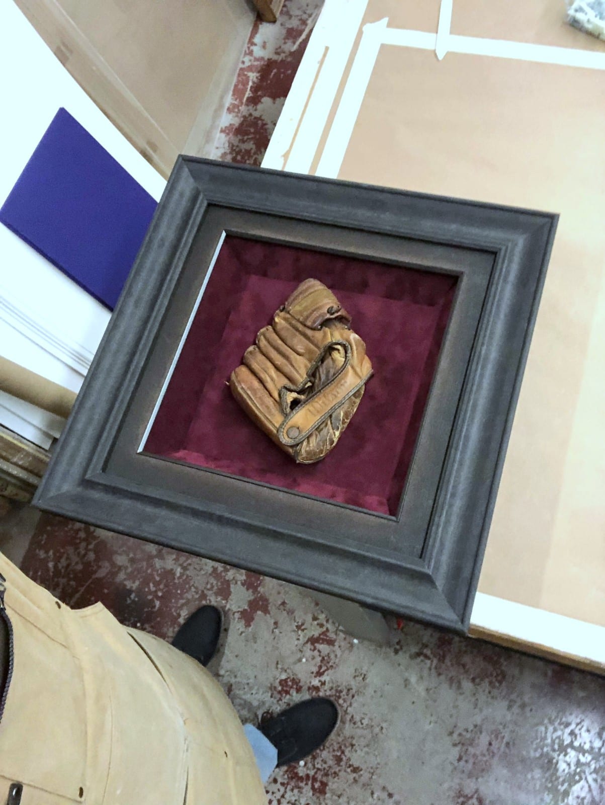 A vintage baseball glove in a deep shadowbox.
