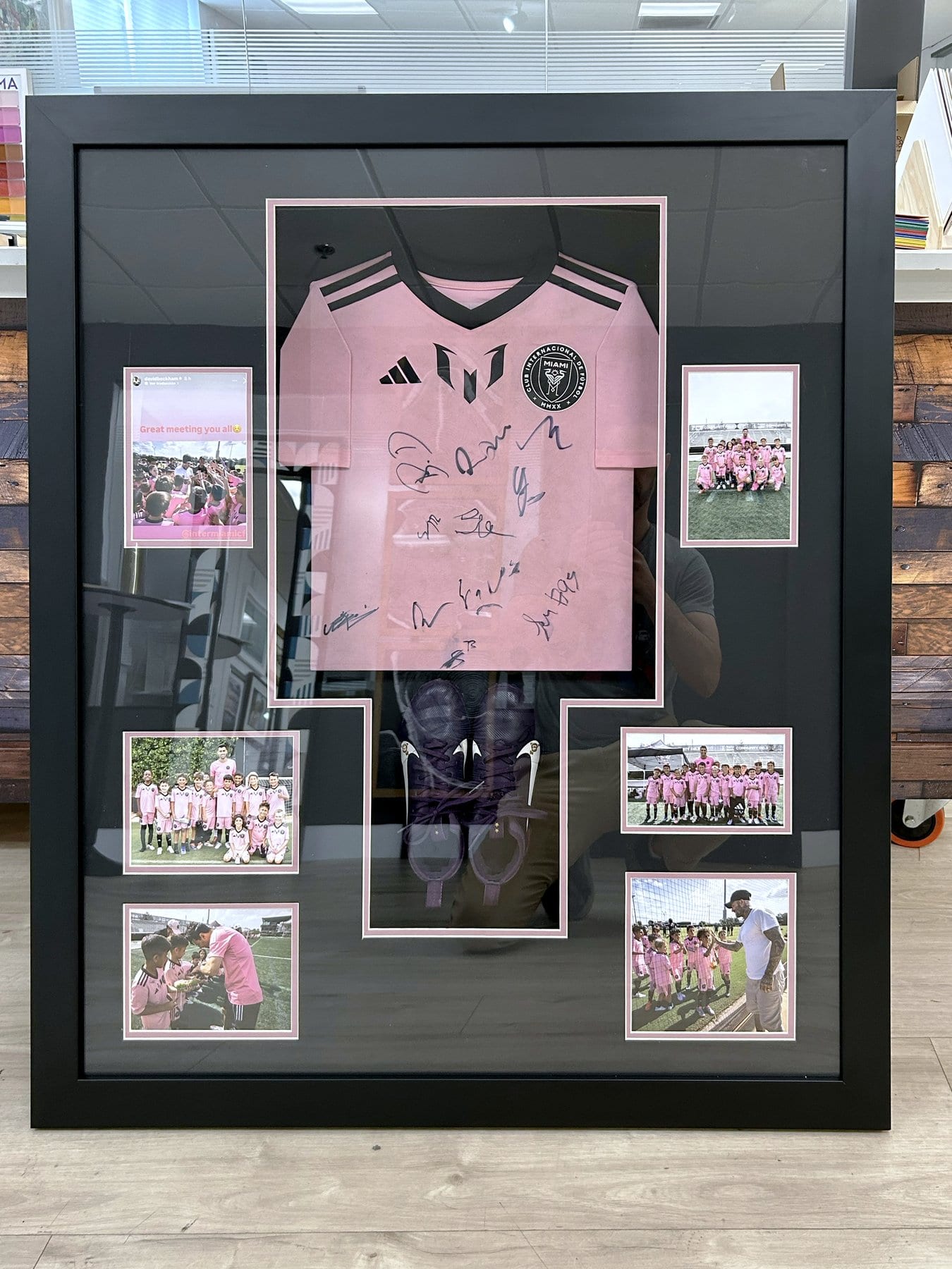 Signed Inter Miami academy jersey and cleats in a black shadowbox.