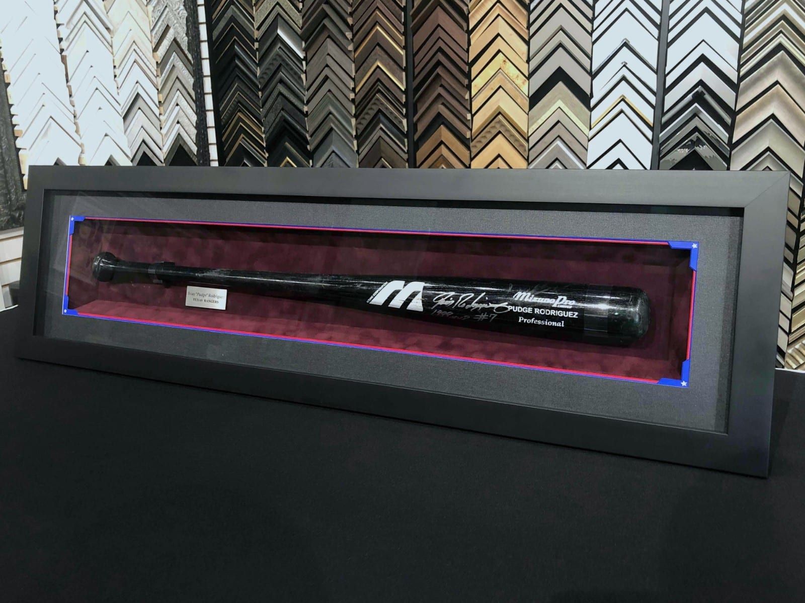 A signed baseball bat in a shadowbox display.
