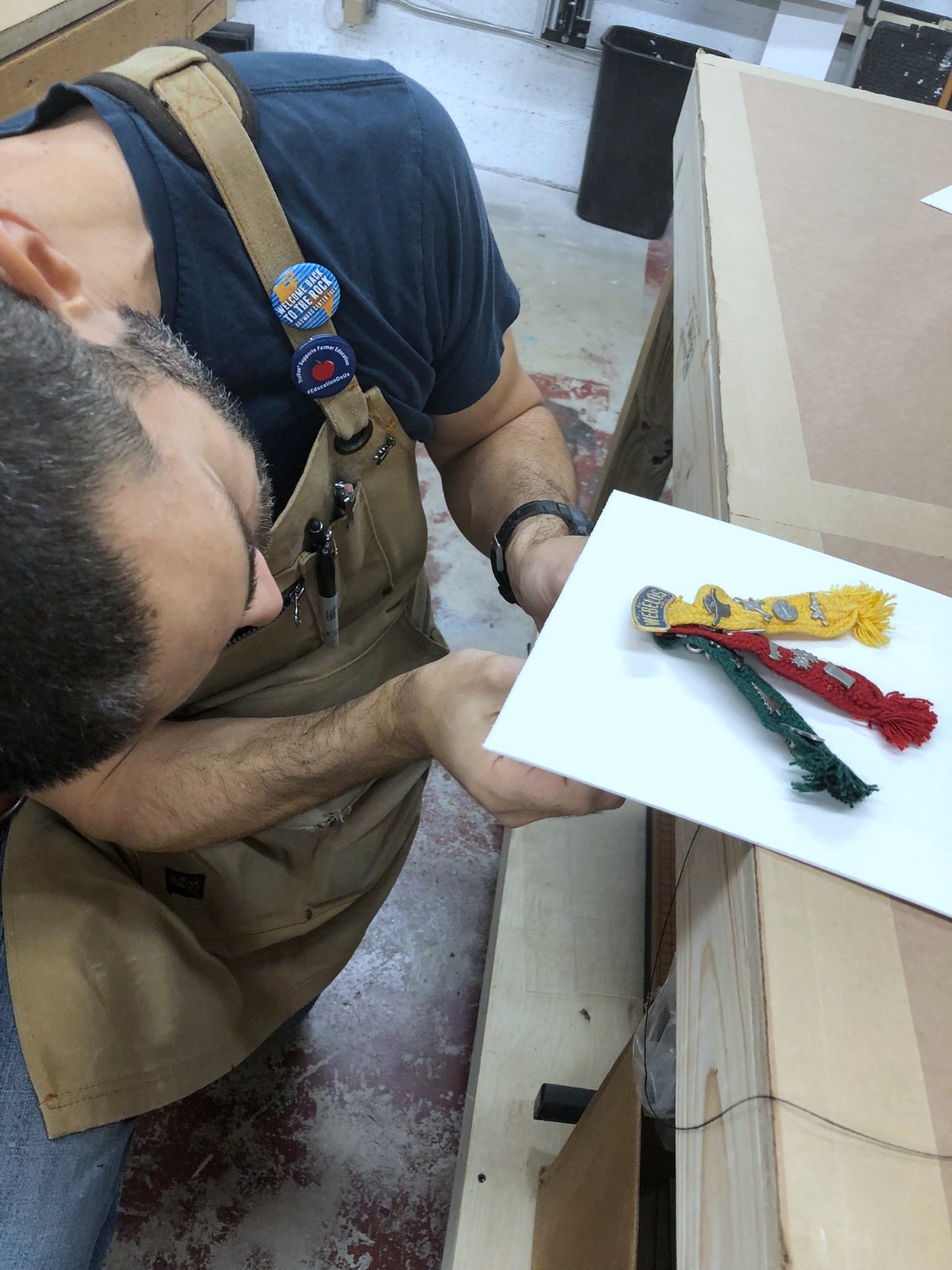 Framer inspecting scout tassels on a mounting board.